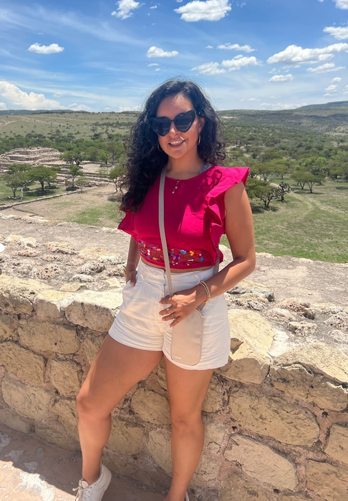 Coach in nature posing for a photo with a white shorts and red blouse.